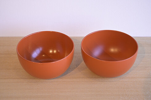 スタッフが約2年間毎日ヨーグルトやカフェオレに使用したカップ（左）と新品（右）。ツヤの違いに注目を。