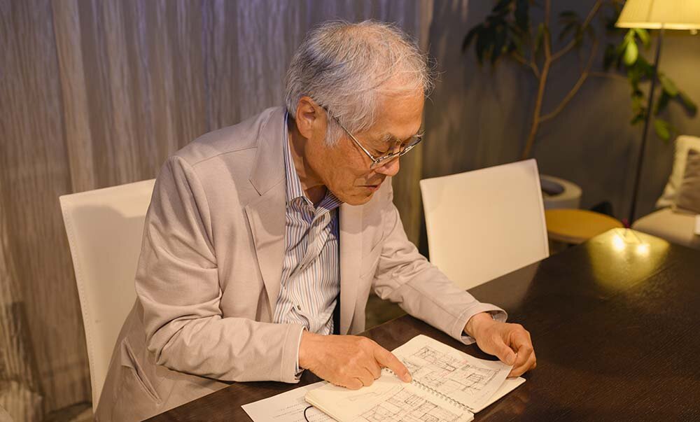藤森氏が常に持ち歩いているという愛用のスケッチブックを見せる写真